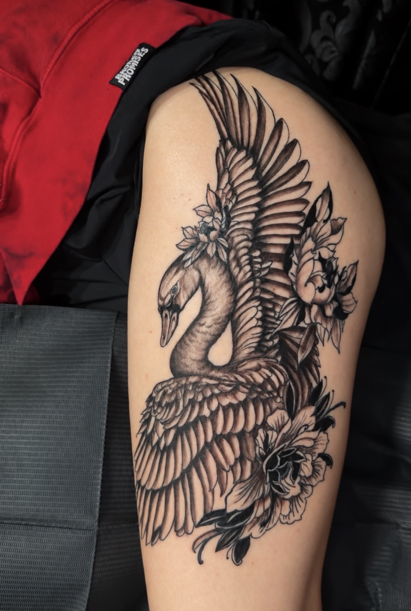 Black-and-gray swan and floral upper-arm tattoo with detailed feathers and soft shading, tattooed by Joseph Rojas